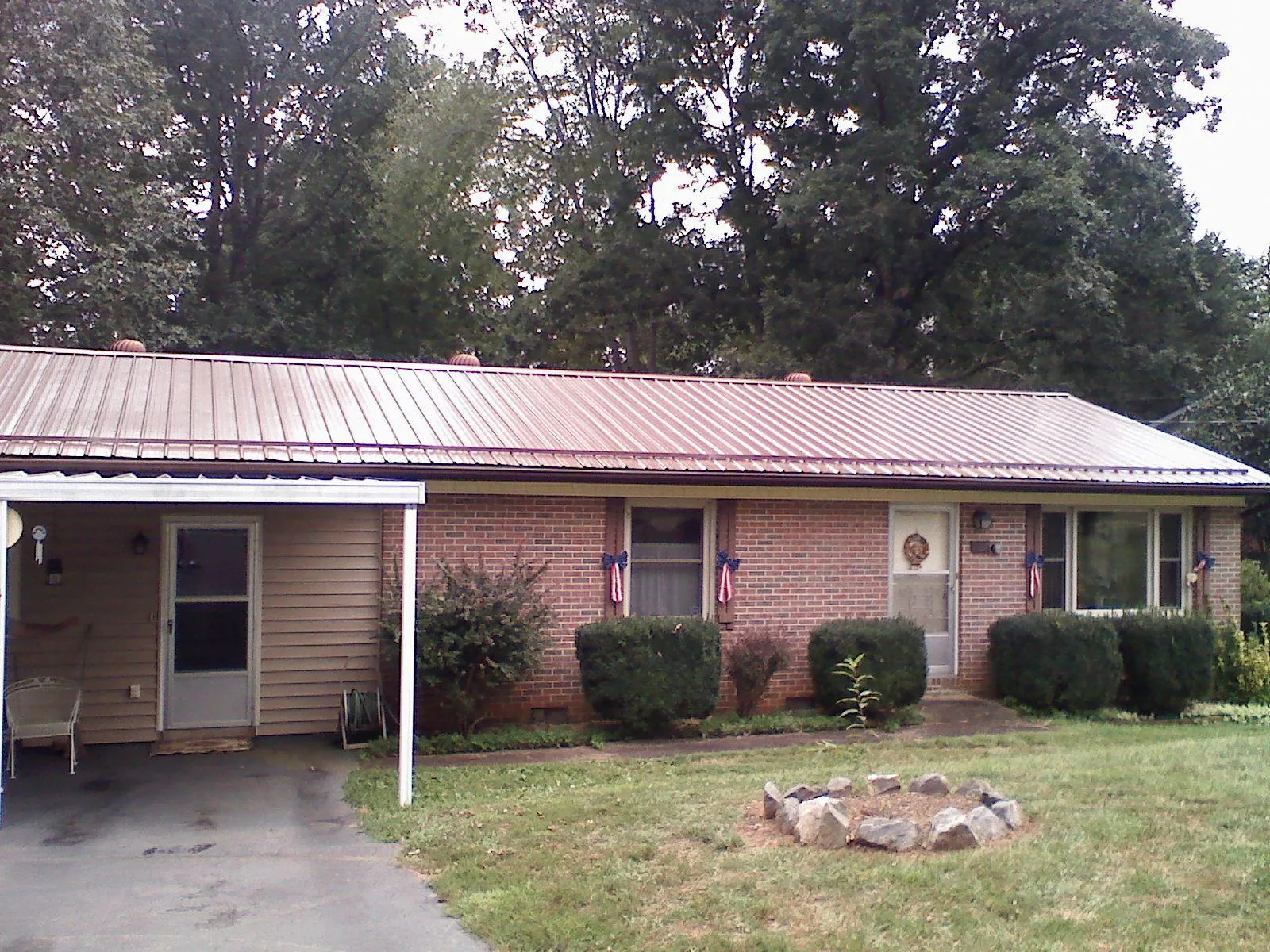 Bronze metal roof and carport on a brick ranch home — Roof Repair work by our crew in Davis City